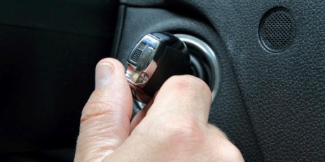 Mann startet sein Auto mit einem Schlüssel.