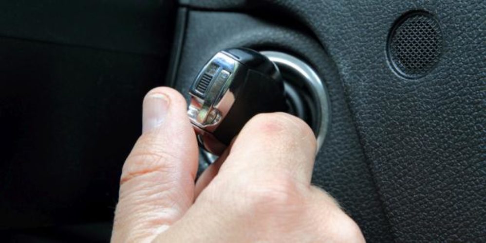 Mann startet sein Auto mit einem Schlüssel.