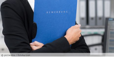 Eine Frau die eine Bewerbungsmappe in der Hand hält.