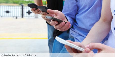 Mehrere Personen in einer Reihe die jeweils ein Handy in der Hand halten.
