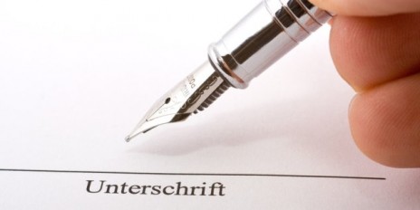 Person hält ein Füller in der Hand und ist dabei etwas zu unterschreiben.