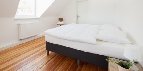 Zimmer mit einem Bett und einer kleinen Kommode.