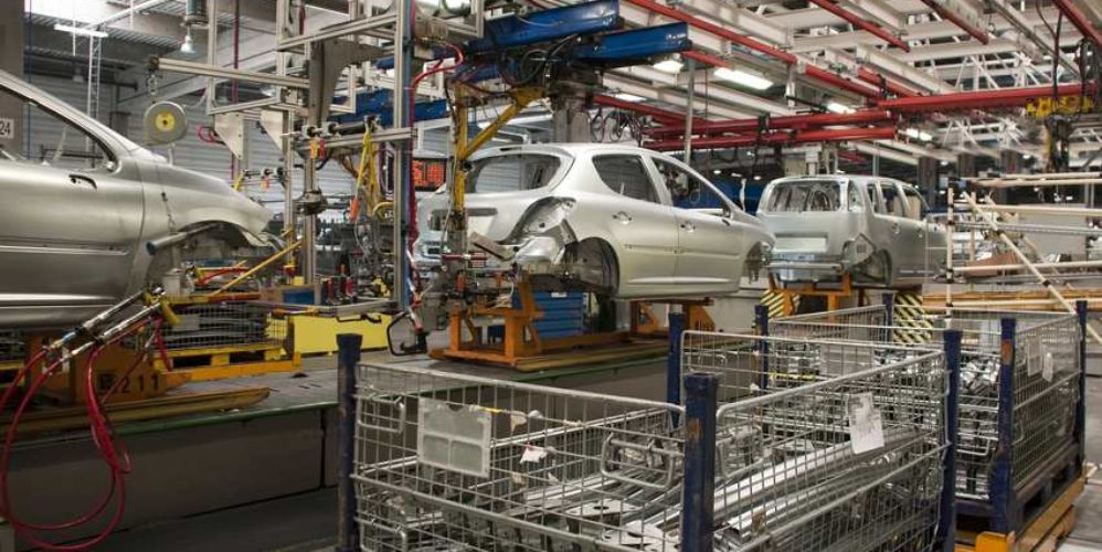 Drei silberne Autos die in der Werkstatt hintereinander stehen.