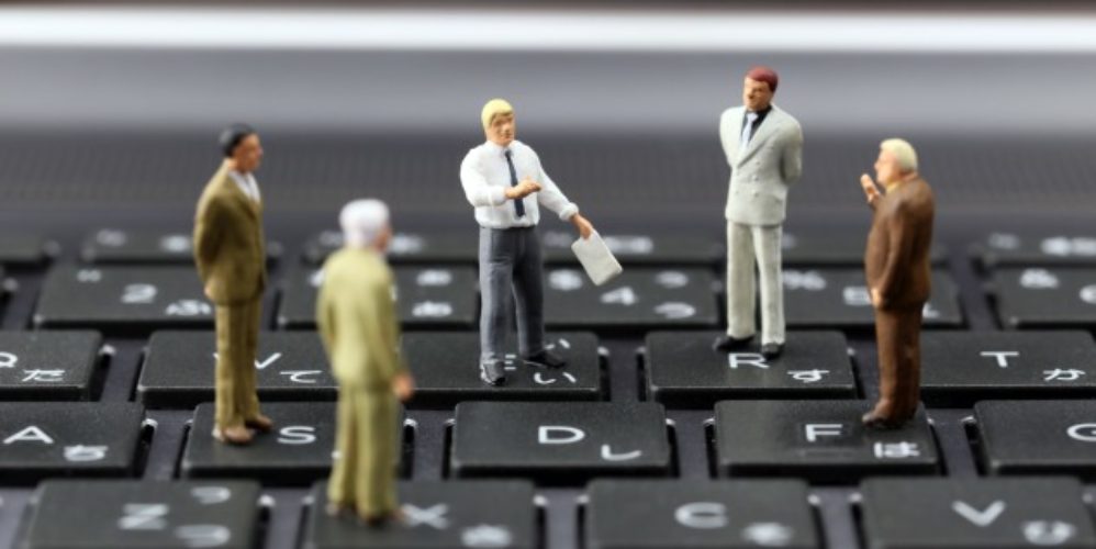 Eine Gruppe von kleinen Figuren die auf einer Tastatur stehen.