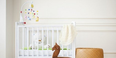 Ein Gitterbett mit Kindersachen.