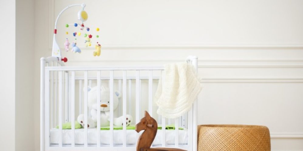 Ein Gitterbett mit Kindersachen.