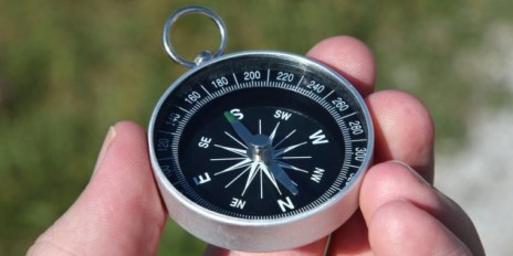 Person hält ein Kompass in der Hand, welcher nach Süden zeigt.