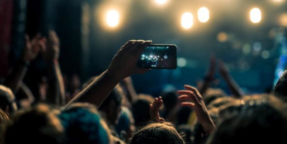 Ein Handy welches ein Video aufzeichnet, auf einen Konzert.