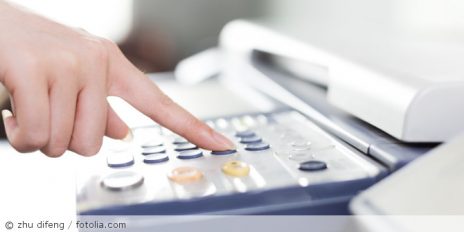 Eine Hand an einen Kopierer.