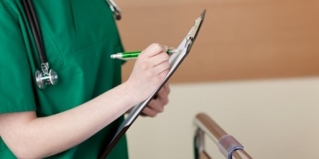 Eine Krankenschwester mit einem Klemmbrett in der Hand.