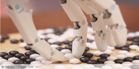 Eine Roboterhand die versucht kleine Steine aufzuheben.