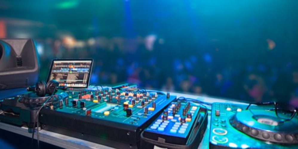 Disco wo der Mischpult im Vordergrund steht.