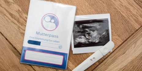 Ein Mutterpass, ein positiver Schwangerschaftstest und ein Ultraschalbild.