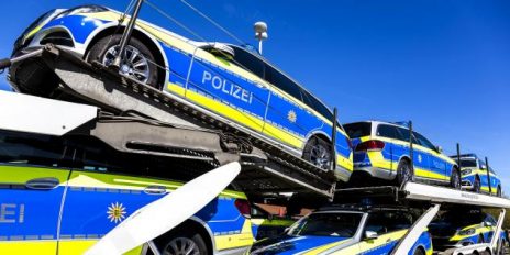Mehrere Polizeiautos auf einem Autotransporter.