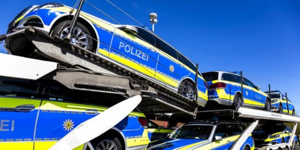 Mehrere Polizeiautos auf einem Autotransporter.