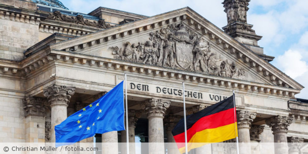 Der Reichstag mit der Deutschland und EU-Flagge.