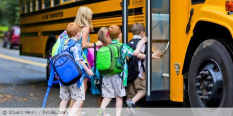 Kinder die in einen Schulbus einsteigen.