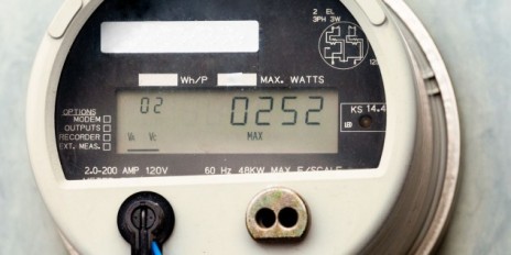 Weißer Smartmeter hängt an der Wand.