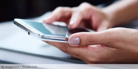 Eine Frau mit einen Smartphone in der Hand.