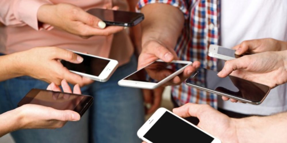 Mehrere Menschen mit Smartphones in der Hand die im Kreis stehen.