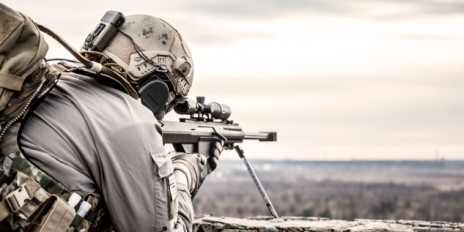 Soldat zielt aus einer hohen Klippe auf etwas.