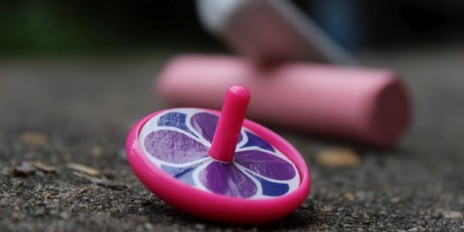 Ein pinkes Spielzeugkreisel liegt auf dem Boden.