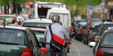 Ein Mann auf einem Fahrrad im Stadtverkehr.