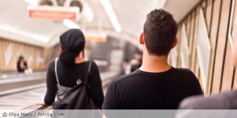 Personen von hinten die sich auf einer Rolltreppe befinden.