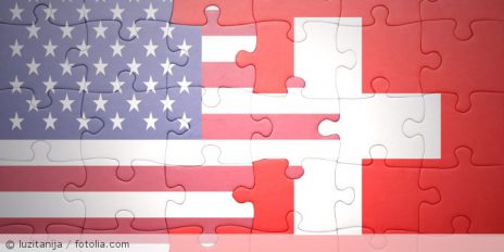 Ein Puzzle mit den Flaggen der USA und der Schweiz.