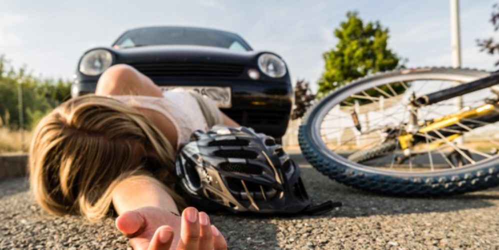 Verkehrsunfall wo die Frau vom Fahrrad gefallen ist und auf dem Boden liegt.