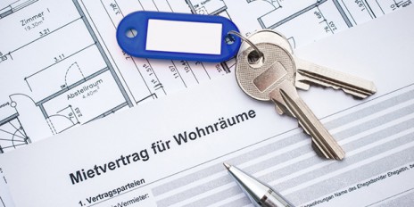Ein Vertrag zur Wohnraumvermietung mit einem Grundriss, einem Hausschlüssel und einem Kugelschreiber.