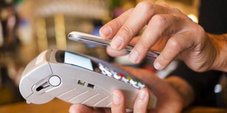 Mann bezahlt sein Einkauf mit seinem Handy.
