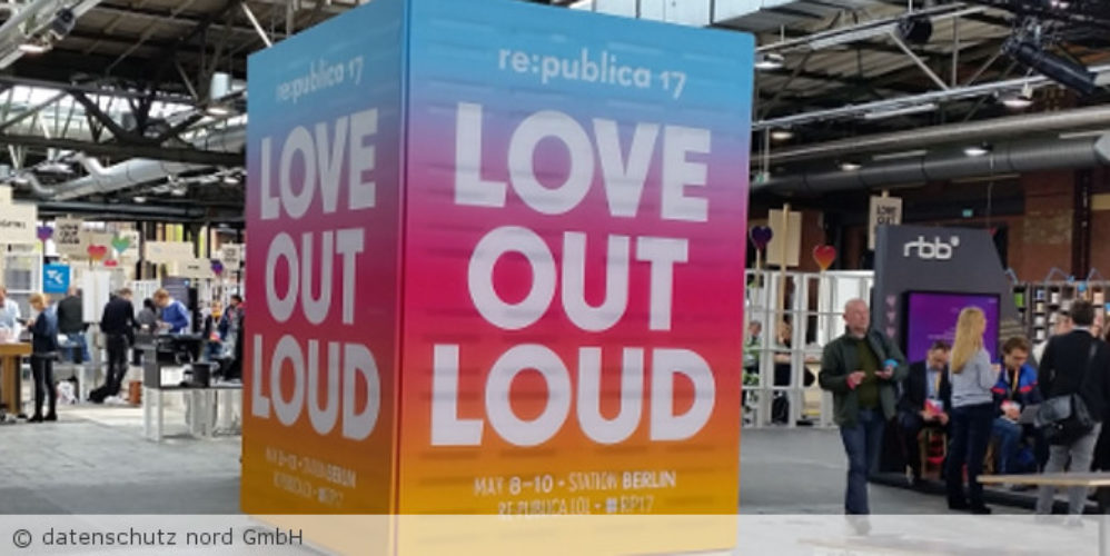 Ein Aussteller mit der Aufschrift "LOVE OUT LOUD" bei einer Messe.