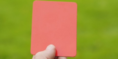 Eine Hand die eine rote Karte hält.