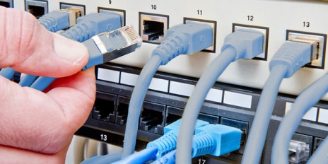 Kabel werden an eine Router angeschlossen.
