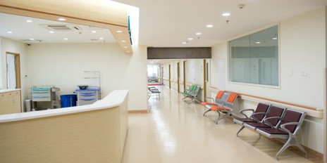 Leeres Krankenhaus mit einer Rezeption und verschiedenfarbigen Stühlen.