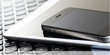 Auf dem Laptop sind gestapelt, ein Ipad und ein Smartphone.
