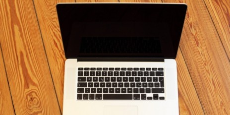 Laptop steht auf einem Holztisch.