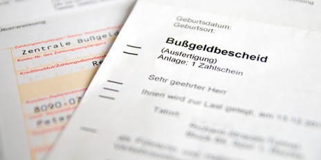 Post mit einem Bußgeldbescheid und einer Überweisung.