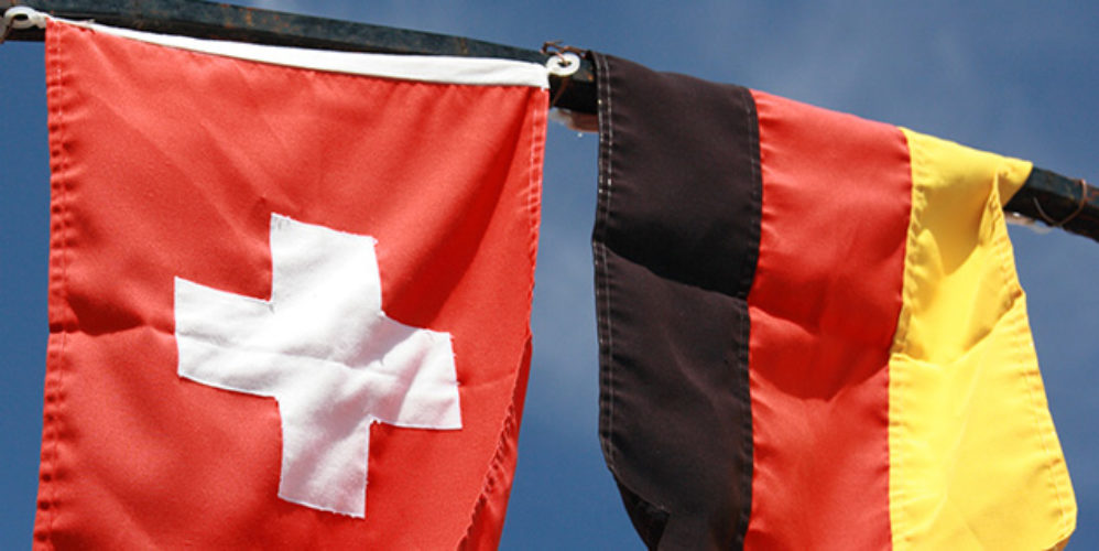 Schweizer Flagge und Deutschland Flagge hängen nebeneinander.