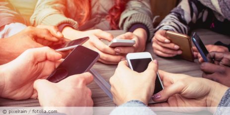 Mehrere Menschen sitzen im Kreis und sind jeweils am Handy.