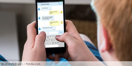 Kind chattet am Handy.
