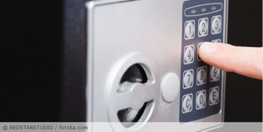 Person tippt Code in Safe ein.