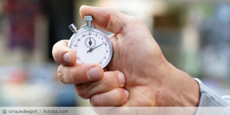 Mann hält Stoppuhr in der Hand.