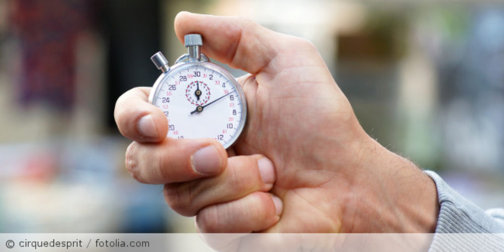 Mann hält Stoppuhr in der Hand.