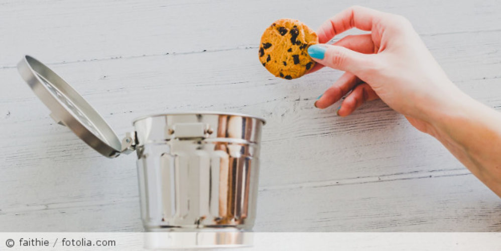 Ein Cookie-Keks der in einen Mülleimer geworfen wird.