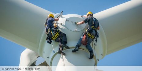Männer reparieren ein Windrad.