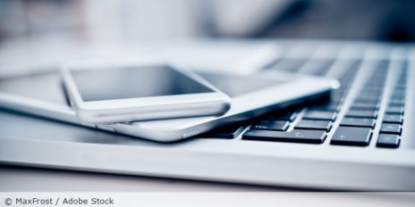 Ein Laptop, ein Tablet und ein Handy übereinander gestapelt.