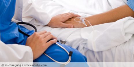 Arzt hält die Hand von einem Patienten.