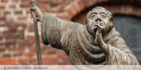 Statur von einen Mönch der seinen Finger vor den Mund hält.